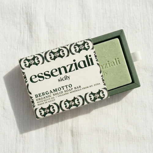 Green soap bar with 'essenziali sicily' packaging on a white background