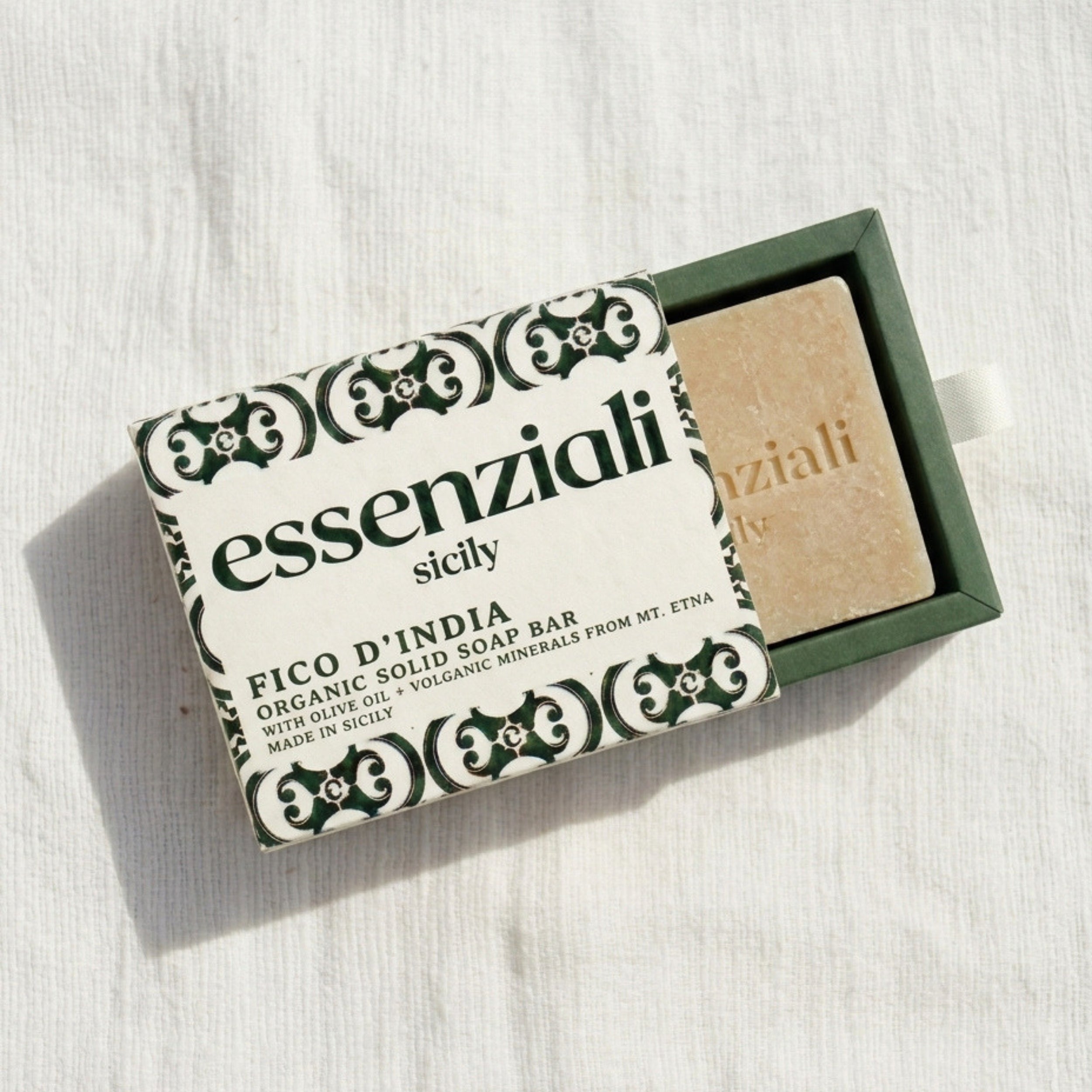 Solid soap bar with packaging labeled 'essenziali sicily' on a white background