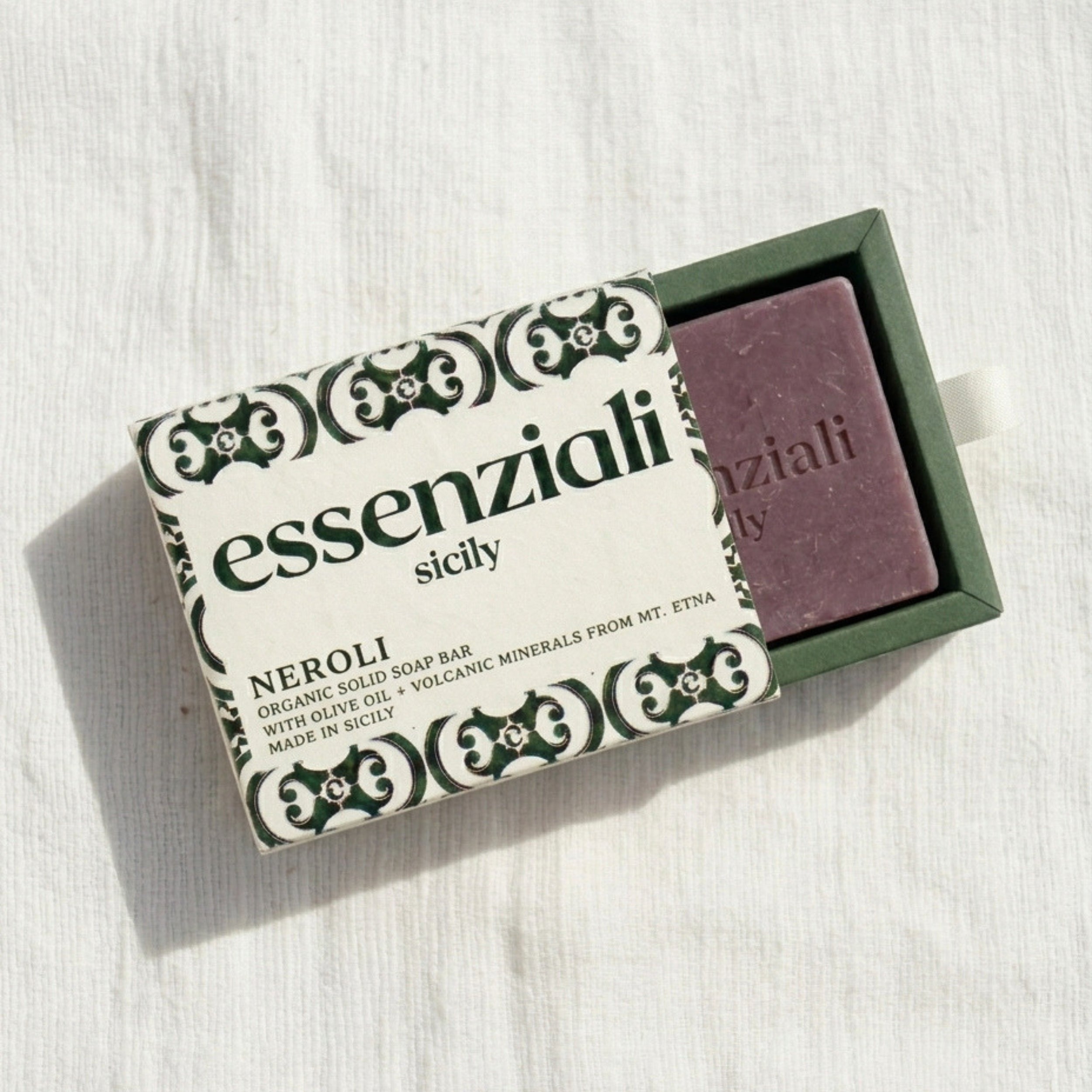 Purple soap bar in a green box with 'essenziali sicily' packaging on a white background